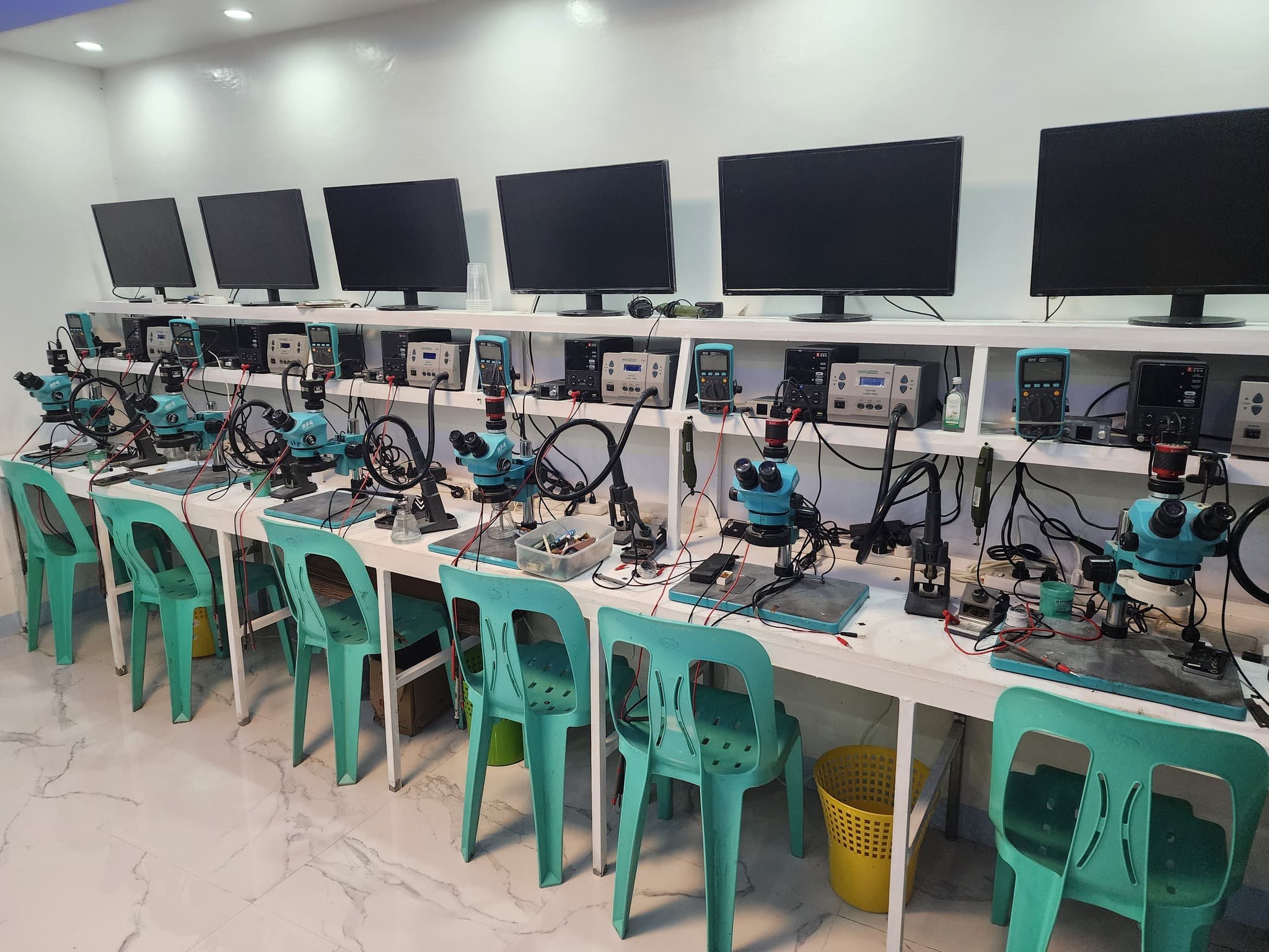 Empty row of microscope repair benches and testing equipment.