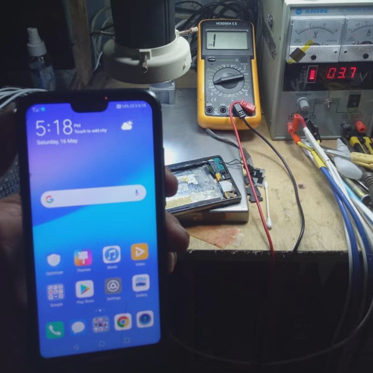 Mobile phone and test instruments on a repair bench.